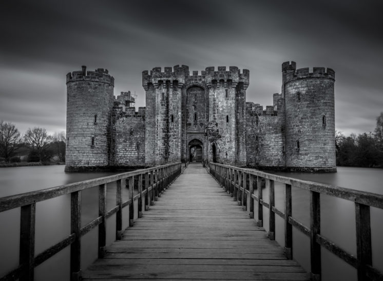 Black and white image of historic and picturesque moated castle in southern England