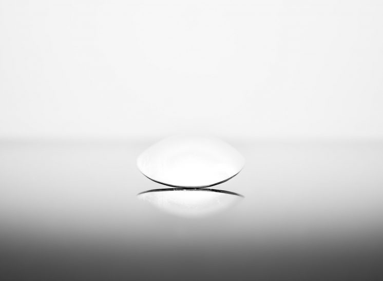 Front view of a dining spoon on black glass