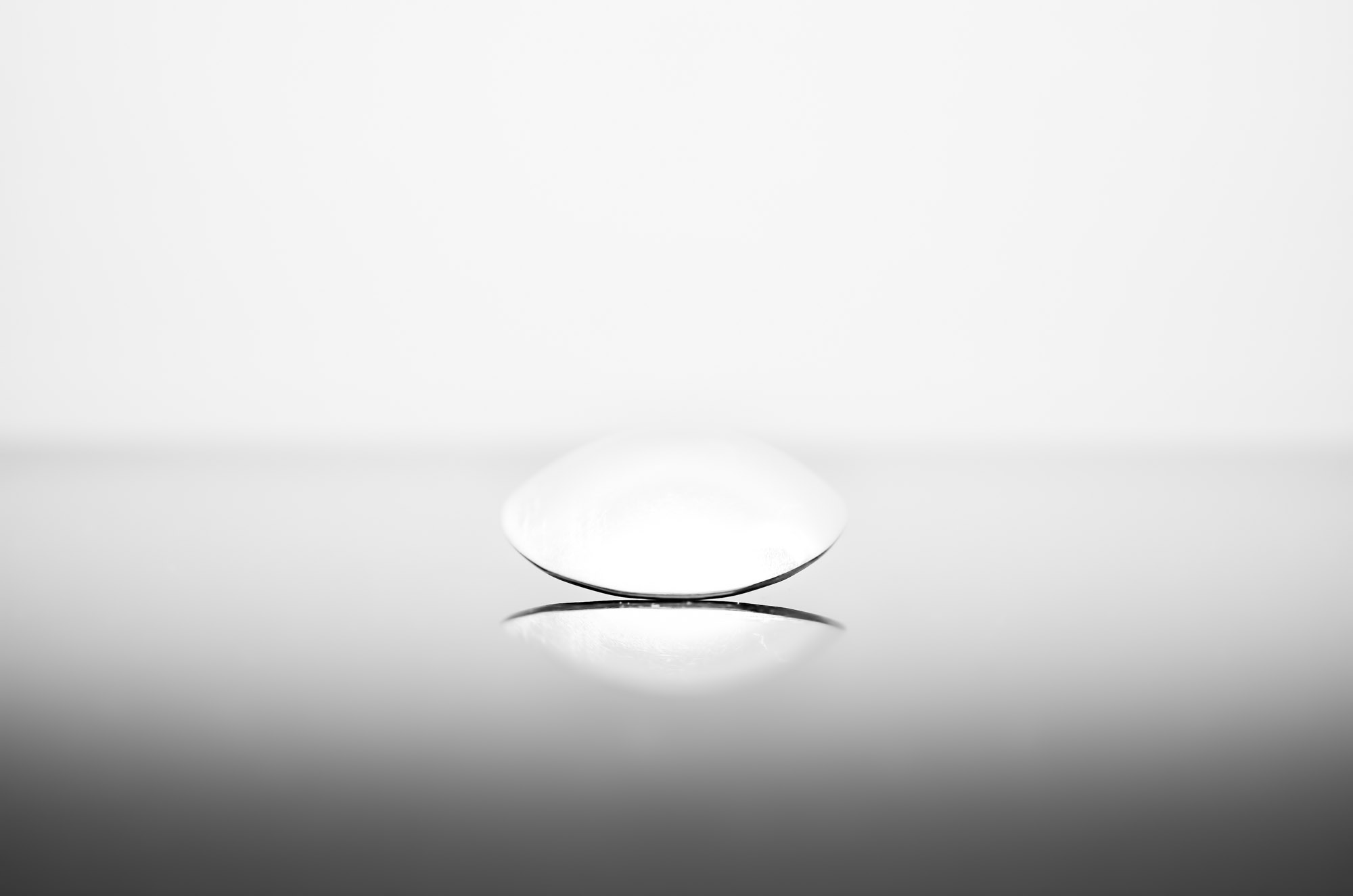 Front view of a dining spoon on black glass