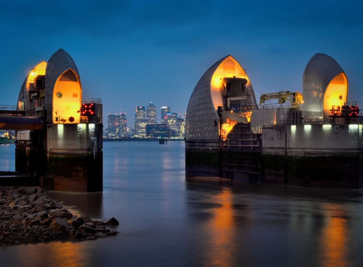 Looking beyond the lights of the Thames Barrier to the Isle of Dogs and Canary Wharf at dusk