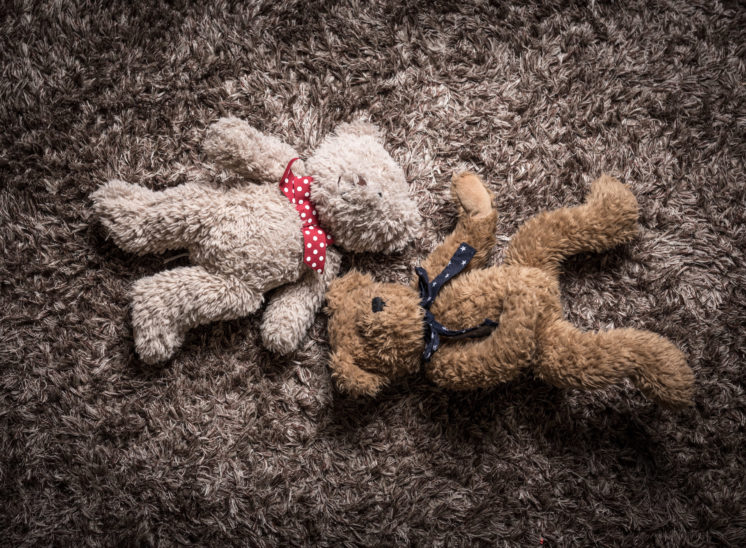 Two abandoned cuddly bears on carpet of similar texture