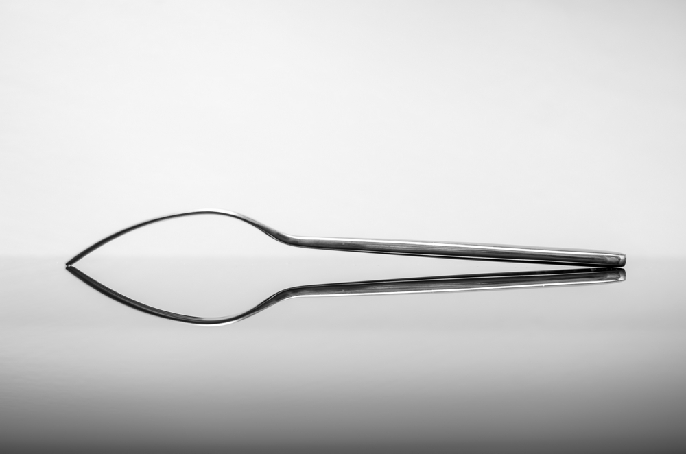 Side profile of a dining fork on black glass
