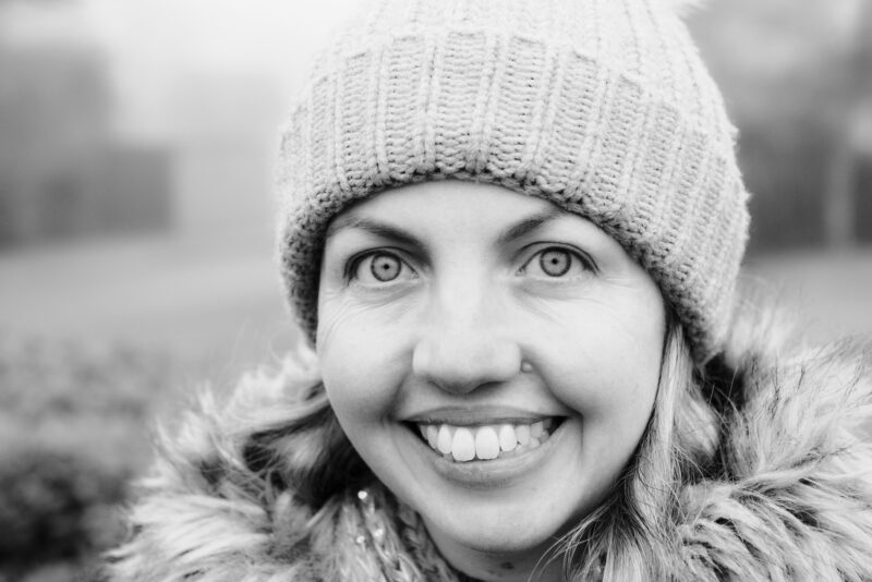 Woman in wooly hat smiling to camera